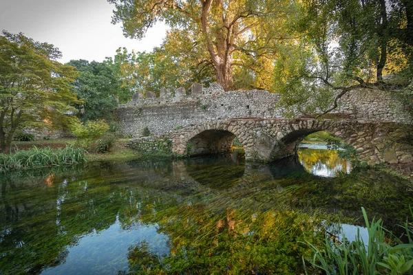 Image of stone bridge with arches and reflection in the water in  province of Latina in Italy