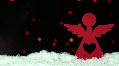 Noel dekorasyon kırmızı ahşap angel ile mevsimlik bokeh arka ışıkları üzerinde kar üzerinde kalp şeklinde delik