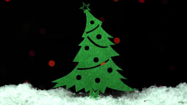 Игрушка Рождественская Елка Снегу Над Мигающей Гирляндой Размыта Темном Фоне — стоковое видео