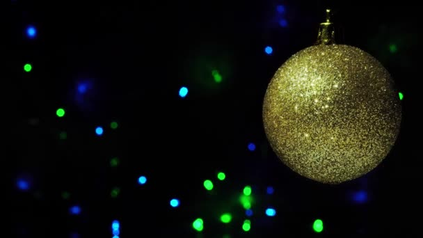 Decoração Natal Bola Dourada Sobre Guirlanda Piscando Azul Fundo Escuro — Vídeo de Stock