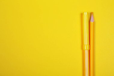 Sarı arka plan üzerinde kopya alanı ile renkli kalemler, okula geri eğitim, satış, alışveriş konsepti.