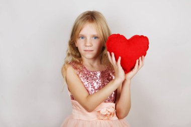  beyaz bir arka plan üzerinde kırmızı kalpli güzel sarışın kız. Sevgililer Günü için kalbi olan çocuk