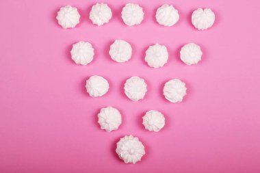 Pembe arka planda vanilyalı beze kurabiye. Üstte görüntü.