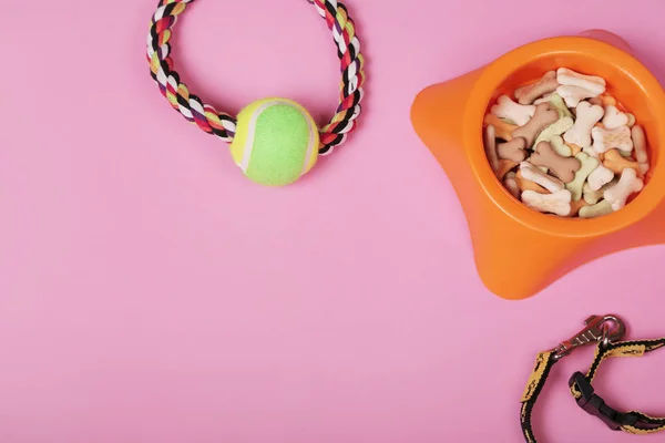 Flat lay composition with accessories for dog and cat, toys, dry food, biscuits, cookies, brushes, hairbrushes, balls, collar on pink background. Pet care — Stock Photo, Image