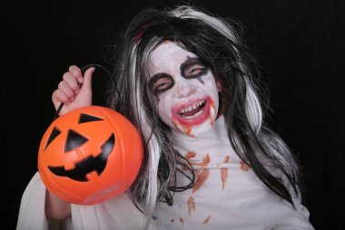 Cadılar Bayramı korku konsepti. Siyah arka plan üzerinde balkabağı ile canavar zombi kostümsevimli küçük korkunç kız.