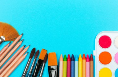 Okul alışveriş konseptine dönelim. Okul, sanat, sanatsal malzemeler mavi arka planda. Düz konum, üst görünüm, kopyalama alanı.