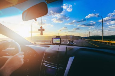 Direksiyon simidi arabanın sürücüsü karayolu üzerinde güneşin üzerinde sürüş sırasında ön cam üzerinde Ortodoks çapraz ve araba navigator ile elleri. Sürüş ve araba konsept sanat resim efektli tarafından seyahat.