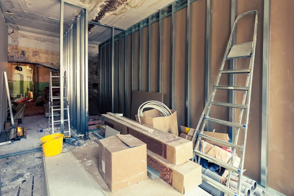Proceso de instalación de marcos metálicos para placas de yeso - paneles de yeso y herramientas de construcción en la habitación del apartamento está en construcción, remodelación, renovación, extensión, restauración y reconstrucción . — Foto de Stock
