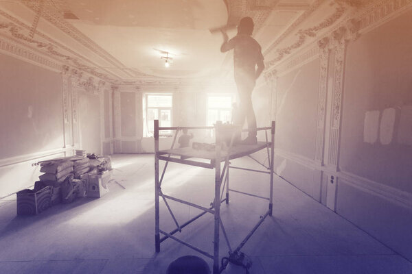 Workers are installing ceiling from wooden platform in apartment is under construction, remodeling, renovation, extension, restoration and reconstruction.Image with tone and gradient effects