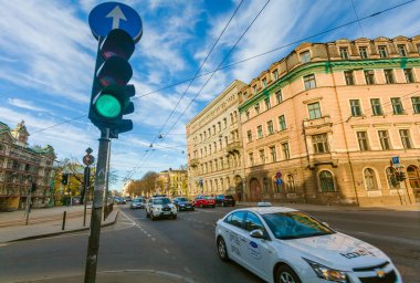 Riga, Letonya - 06 Mayıs 2017: Görünüm üzerinde kavşak ile toplu taşıma ve arabalar ve Riga şehir merkezi bulunur yeşil trafik ışığı