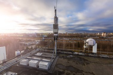 Panel anten Gsm Dcs Umts Lte grup ve telsiz birimi teknik temel istasyonunun parçası çatıda yüklenir ve arka plan olarak gökyüzü ve şehir gibi vardır