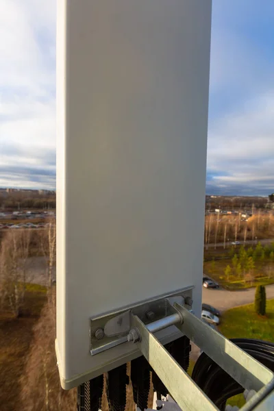 Gsm dcs umts lte 波段的面板天线作为基本站通信设备的一部分安装在管状桅杆上, 天空和城市都以地面为背景 — 图库照片