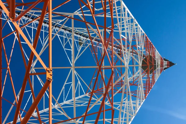 Telecommunications tower with microwave antennas and satellite dishes with cables and fiber optic.