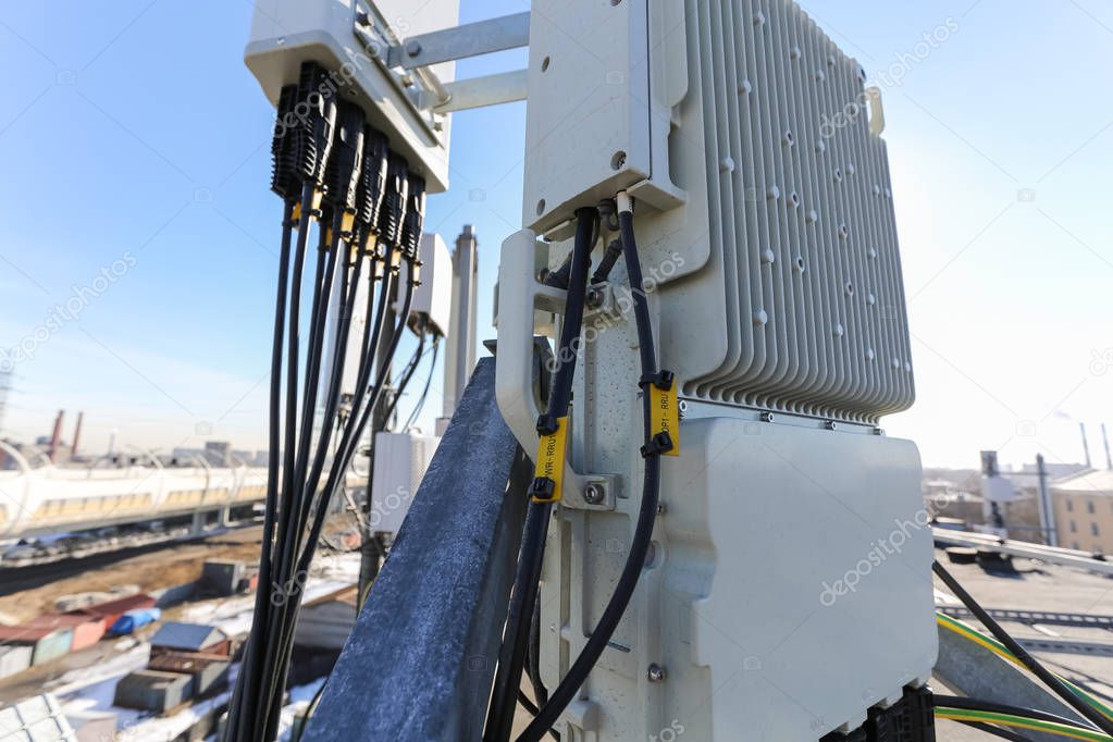 Panel antenna of GSM DCS UMTS LTE bands and outdoor remote radio unit are as part of communication equipment of basic station are installed on the tubular mast on the roof.