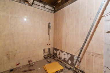 Duvarlar ile duşlu banyo döşenir ve inşaat çöp tadilat, yenileme, restorasyon ve yeniden yapım aşamasındadır daire bulunmaktadır. Ev geliştirme kavramı.