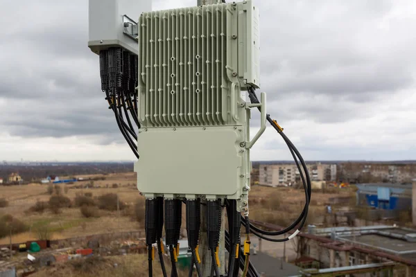 Outdoor remote radio unit of GSM DCS UMTS LTE is as part of communication equipment of basic station are installed on the tubular mast on the roof — Stock Photo, Image