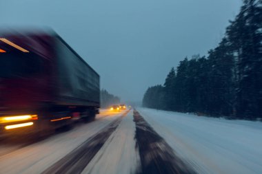 Kamyon farları ile ne zaman uçan kar alacakaranlıkta bir kar fırtınası de kış yol kullanıyor. Tehlikeli koşullarda kötü görünürlük ile üzerinde kış sürüş kavramı. Moti resimle