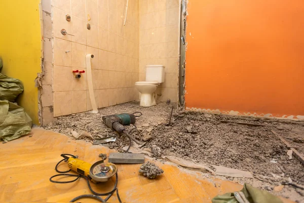 WC kamer of toilet met oude WC kom en bouw hulpprogramma's - perforator en Haakse slijper zijn in appartement dat is in aanbouw, verbouwing, renovatie, revisie, restauratie en uitbreiding — Stockfoto