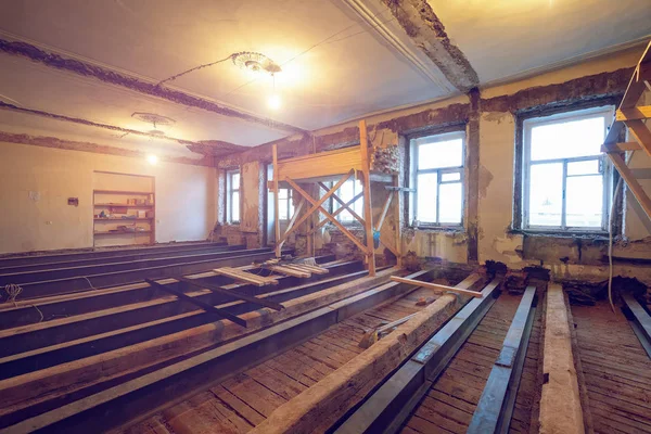 The process of installing new floor from double-tee girder and wooden joist in huge room in apartment that is under construction, remodeling, renovation, overhaul, extension, restoration and — Stock Photo, Image