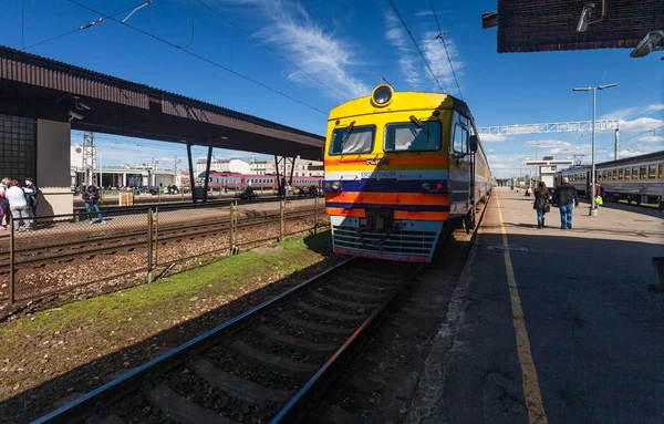 Riga, Lotyšsko - 7. května 2017: Cestující a vlakem se na nástupišti hlavního nádraží v Rize, Lotyšsko — Stock fotografie