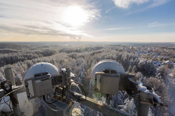 Torre de telecomunicaciones o mástil con microondas de alta capacidad al aire libre y equipo de paquetes de grado portador con antenas en el día de invierno . — Foto de Stock
