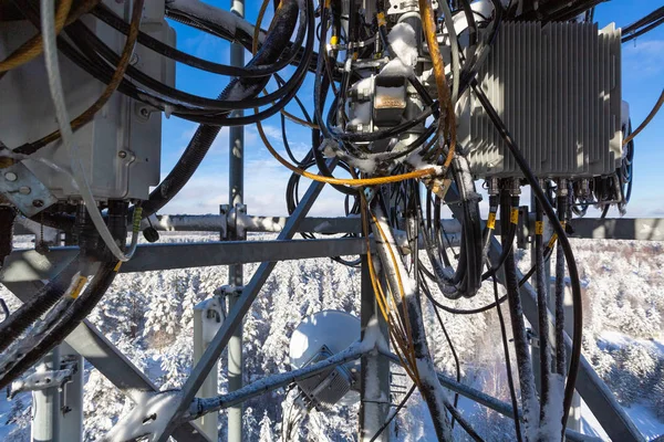 Torre de telecomunicaciones o mástil con microondas, antenas de panel de radio, unidades de radio remotas al aire libre, cables de alimentación, cables coaxiales, fibras ópticas están en el mástil superior que se encuentra en las zonas rurales . — Foto de Stock