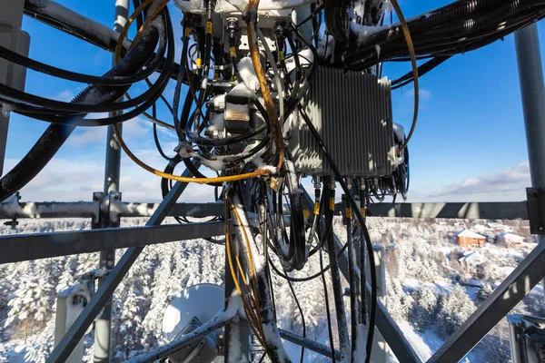 Telecommunication tower or mast with microwave, radio panel antennas, outdoor remote radio units, power cables, coaxial cables, optic fibers are on the top mast that located in rural. — Stock Photo, Image