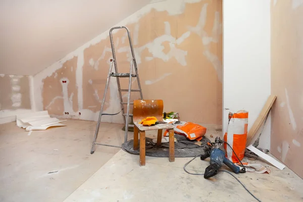 正在建造、改造、翻新、扩建带有干墙或石膏石膏板的房间和带有建筑材料的梯子的翻新房间的工作过程 — 图库照片