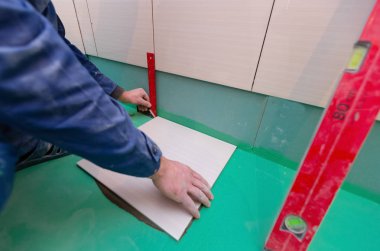 Banyo karoları değiştirme. Beyaz işçi yeni Seramik Karo yükleme banyo halis inşaat, tadilat, yenileme, revizyon, uzantısı, restorasyon ve yeniden yapılanma olduğunu. Kavramı