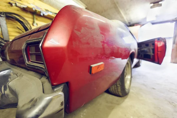 Restoration of classic red car. Close up view front side classic car and  bumper of  broken dusty car during road accident and has been reconstructed in garage. Restoration of classic car. — Stock Photo, Image