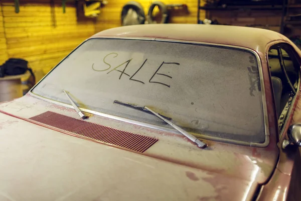 Άποψη των παλαιών αυτοκινήτων στο γκαράζ με κουκούλα σκονισμένο βρώμικο αέρα οθόνη με τίτλο πώληση δάχτυλο και σπασμένο παρμπρίζ υαλοκαθαριστήρα. Έννοια της πώλησης προ-ὀρθὰ αυτοκίνητα. — Φωτογραφία Αρχείου