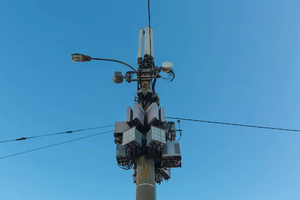 통신 장비, 라디오 패널 안테나, 야외 원격 라디오 단위, 전원 케이블, 동축 케이블, 광섬유 섬유는 도시에 있는 도시 빛 기둥 위에. 모바일의 개념 — 스톡 사진