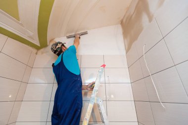 İşçi sokmaktadırlar yukarı merdiven dairede duvardan yapım aşamasında, tadilat, yenileme, revizyon, uzantısı, restorasyon ve yeniden yapılanma olduğunu. Ev geliştirme kavramı.