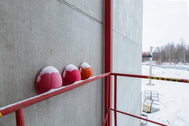 Eski, yıpranmış, renkli ve emniyet kask mühendislik inşaat işçileri kar ile şantiye el parmaklıklar üzerinde vardır.
