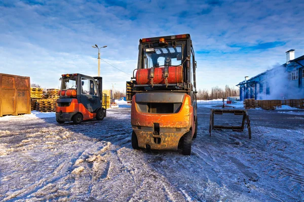 Forklift loaders for warehouse are waiting work outdoors during frosty day in the cargo center. Pallet stacker trucks in winter. — Stock Photo, Image