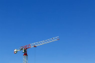 Endüstriyel inşaat vinç veya sütun-jib vinç ile kabin inşaat ve mavi gökyüzü üzerinde çalışır bir arka plan. Metniniz için alan.