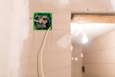 Alçı duvarlar için alçıpan veya alçıpan monte edilmiş elektrik telleri ile bitmemiş elektrik şebekesi prizi soketi ve dairede gizli kanal yapım aşamasındadır, tadilat, yeniden inşa