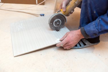 İşçi, inşaat, tadilat, yenileme, elden geçirme, uzatma, restorasyon ve yeniden yapılanma halindeki dairede açı öğütücü kullanıyor. Toplam ev iyileştirmesi kavramı.