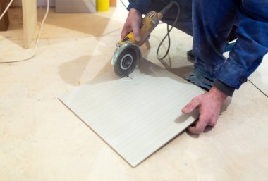 İşçi, inşaat, tadilat, yenileme, elden geçirme, uzatma, restorasyon ve yeniden yapılanma halindeki dairede açı öğütücü kullanıyor. Toplam ev iyileştirmesi kavramı.