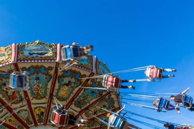 Rusya, Saint Petersburg - 31 Ağustos 2019: Divo Ostrov eğlence parkı. Neşeli çocuklar ve yetişkinler ile Carousel. Hareket efekti