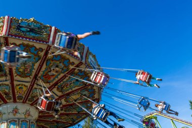 Rusya, Saint Petersburg - 31 Ağustos 2019: Divo Ostrov eğlence parkı. Neşeli çocuklar ve yetişkinler ile Carousel. Hareket efekti