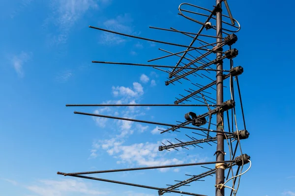 Las antenas de televisión están en el mástil y el cielo azul como fondo — Foto de Stock