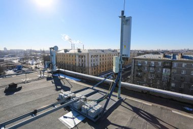 Rusya, Saint-Petersburg - 30 Nisan 2018: 5G, 4G, 3G, 2G bantları, optik fiberler, güç kabloları ve uzaktan kumandalı radyo üniteleri temel telekomünikasyon istasyonunun iletişim ekipmanlarının bir parçası olarak çatıya kurulmuştur. Dışarıda.