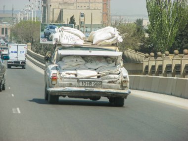 Azerbaycan, Bakü - 03 Mayıs 2007: İnşaat malzemelerinin aşırı yüklediği bagajı olan klasik Sovyet klasik VOLGA GAZ otomobili