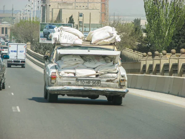 Azerbaijan, Baku - May 03, 2007: Classic soviet vintage sedan car VOLGA GAZ with trunk that is overload by construction materials — Stock Photo, Image