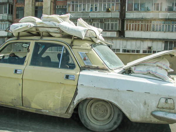 Klassisches sowjetisches Oldtimer-Limousinenauto VOLGA GAZ mit Kofferraum, der von Baumaterialien überladen ist — Stockfoto