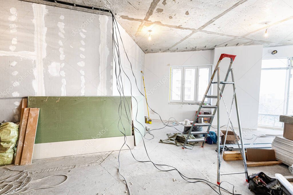 Working process of renovate room with installing drywall or gypsum plasterboard and ladder with construction materials are in apartment is under construction, remodeling, renovation, extension