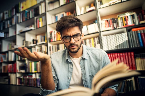 Portrét Mladého Studenta Zamyšlený Čtení Knihy Knihovně — Stock fotografie