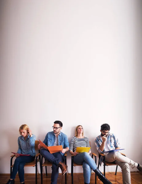 Grupo Jóvenes Sonrientes Confiados Sentados Fila Sala Espera Con Carpetas — Foto de Stock