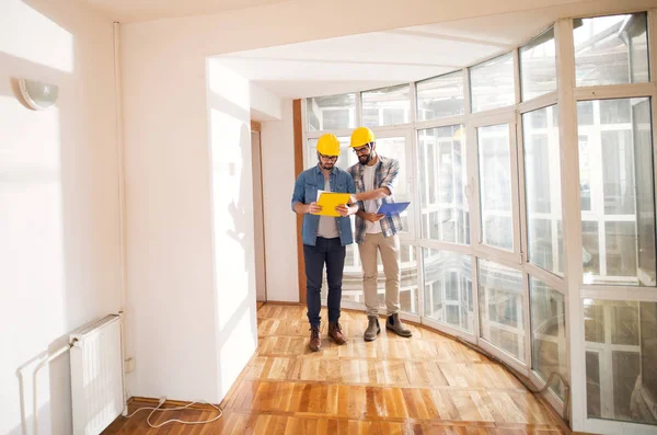 Dois Jovens Engenheiros Profissionais Focados Com Capacetes Consultoria Sobre Projeto — Fotografia de Stock